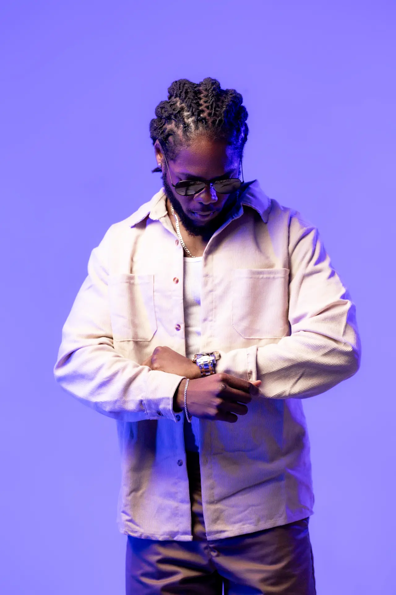 Saint Chris editorial pose in blue studio light.
